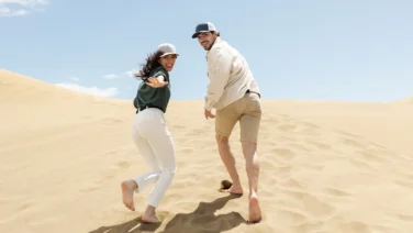 Couple walking on Dubai’s golden desert dunes during a travel adventure