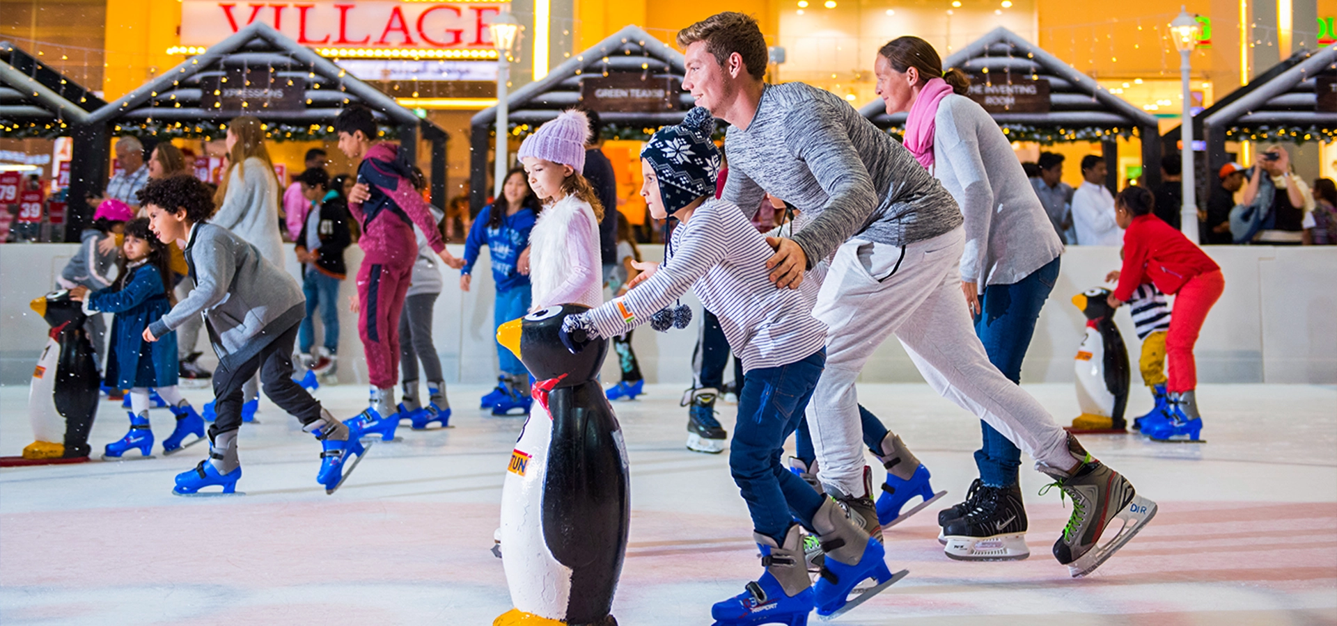 Guests skating at Dubai Ice Rink inside The Dubai Mall under bright lights