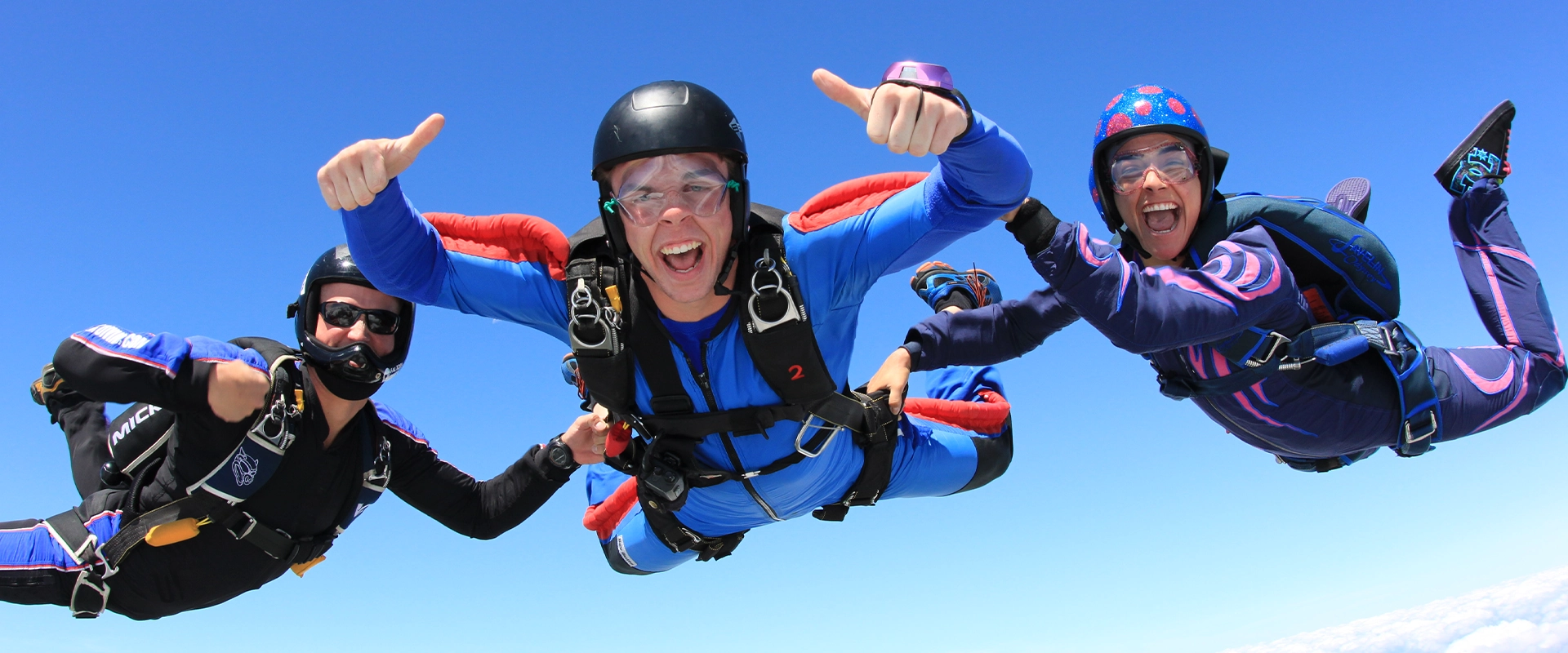 Tandem skydiver freefalling over Palm Jumeirah with stunning aerial Dubai skyline view.